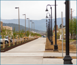 New paved and tree-lined walking path with street lights